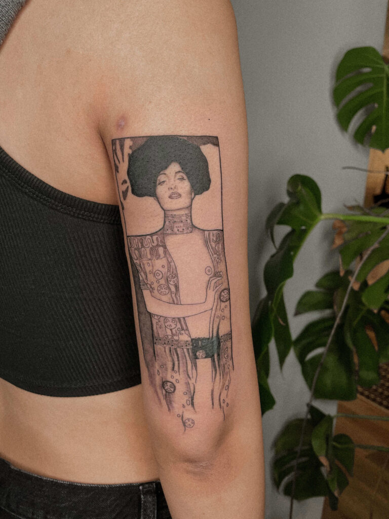 Klimt inspiriertes Tattoo auf Oberarmrückseite tätowiert von Nadine Migesel