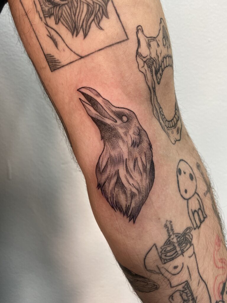Rabenkopf-Tattoo auf einem Arm, gestaltet von Resident Tattoo-Künstlerin Basja.