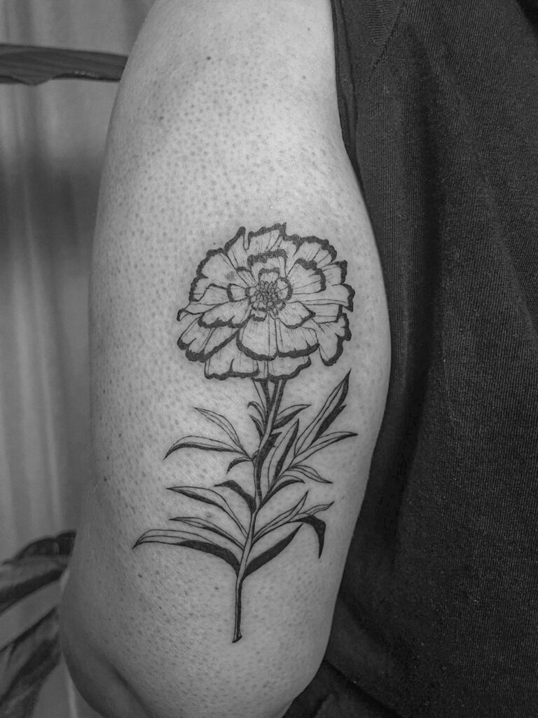 Feinliniges Blumentattoo auf einem Oberarm, gestochen von der Apprentice Künstlerin Lea.