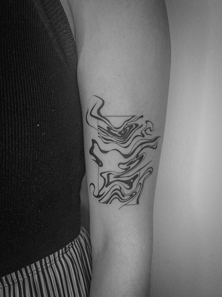 Grafisches Linien-Tattoo auf einem Arm, gestaltet von Apprentice Tattoo-Künstlerin Lea.