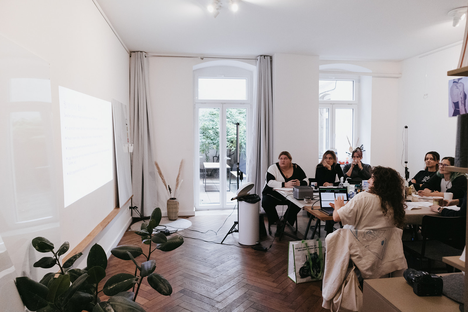 Teilnehmer:innen des Ink Riot Workshops im Workshop Raum während einer Gruppenlektion.