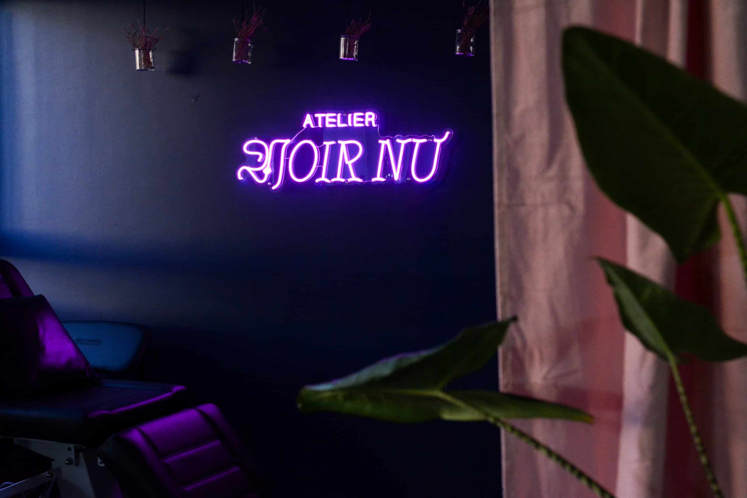 Studioansicht mit Neon-Schriftzug Atelier Noir nu und Liege im Tattoo Studio Köln Ehrenfeld